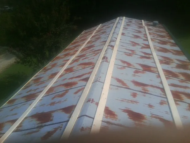 Rusted metal roof panels with new wood purlins before replacement — Storm Damage Roof Repair in Erieville by Roofing Brothers